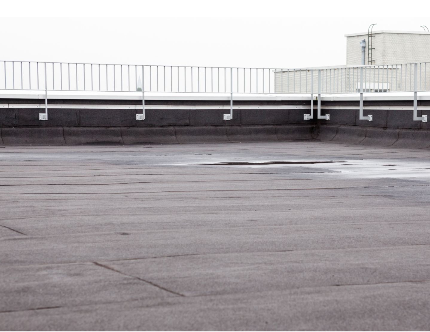 Modified bitumen flat commercial roof with safety railing