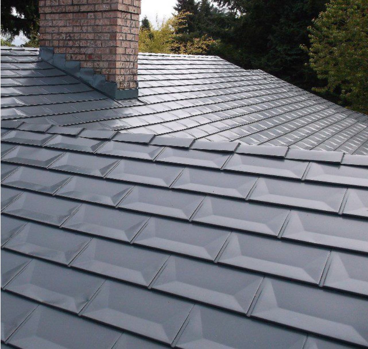 Slate-gray stamped metal shingle roof with brick chimney